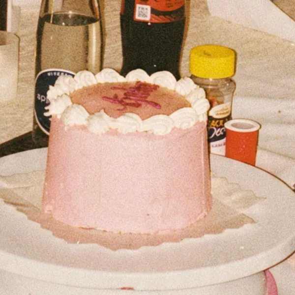 Rosa Torte mit Buttercreme-Tupfen und Schriftzug